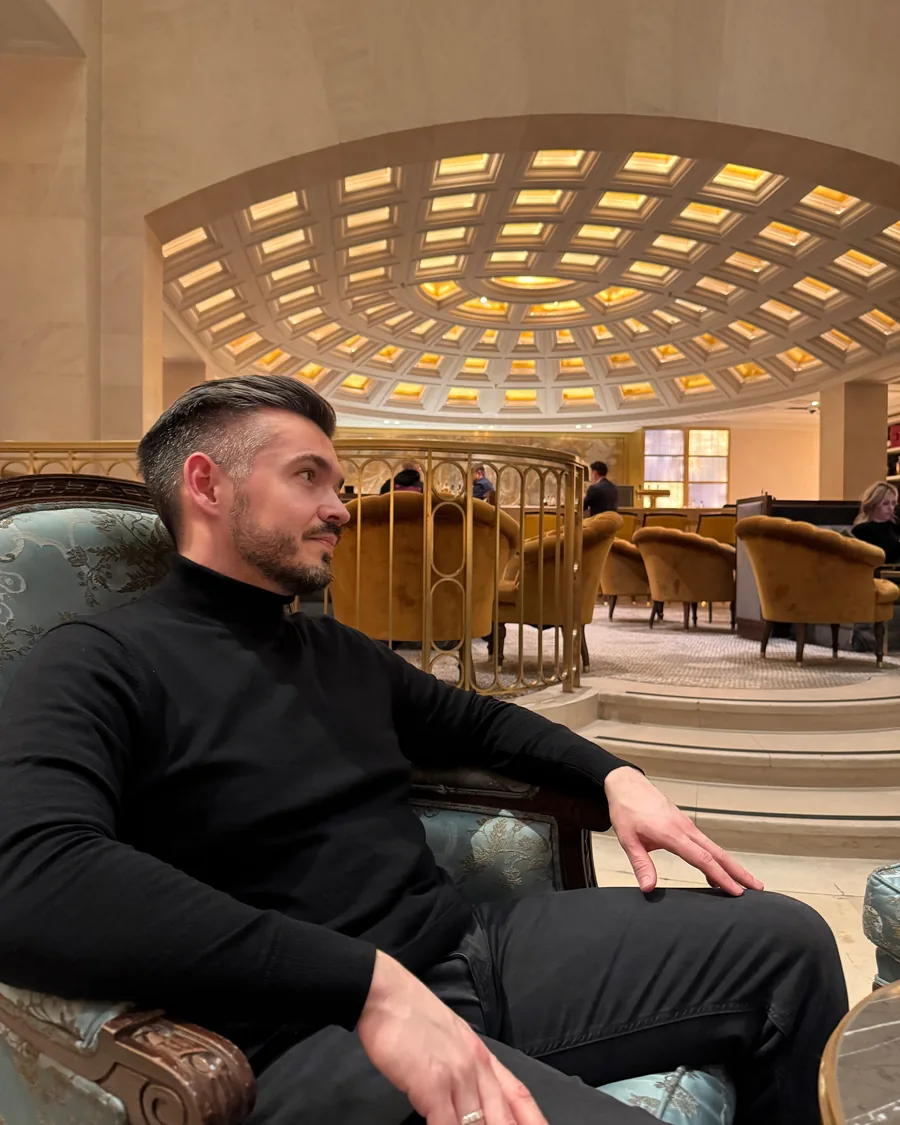 Artur Neumann sitzt in einer eleganten Hotel-Lobby
